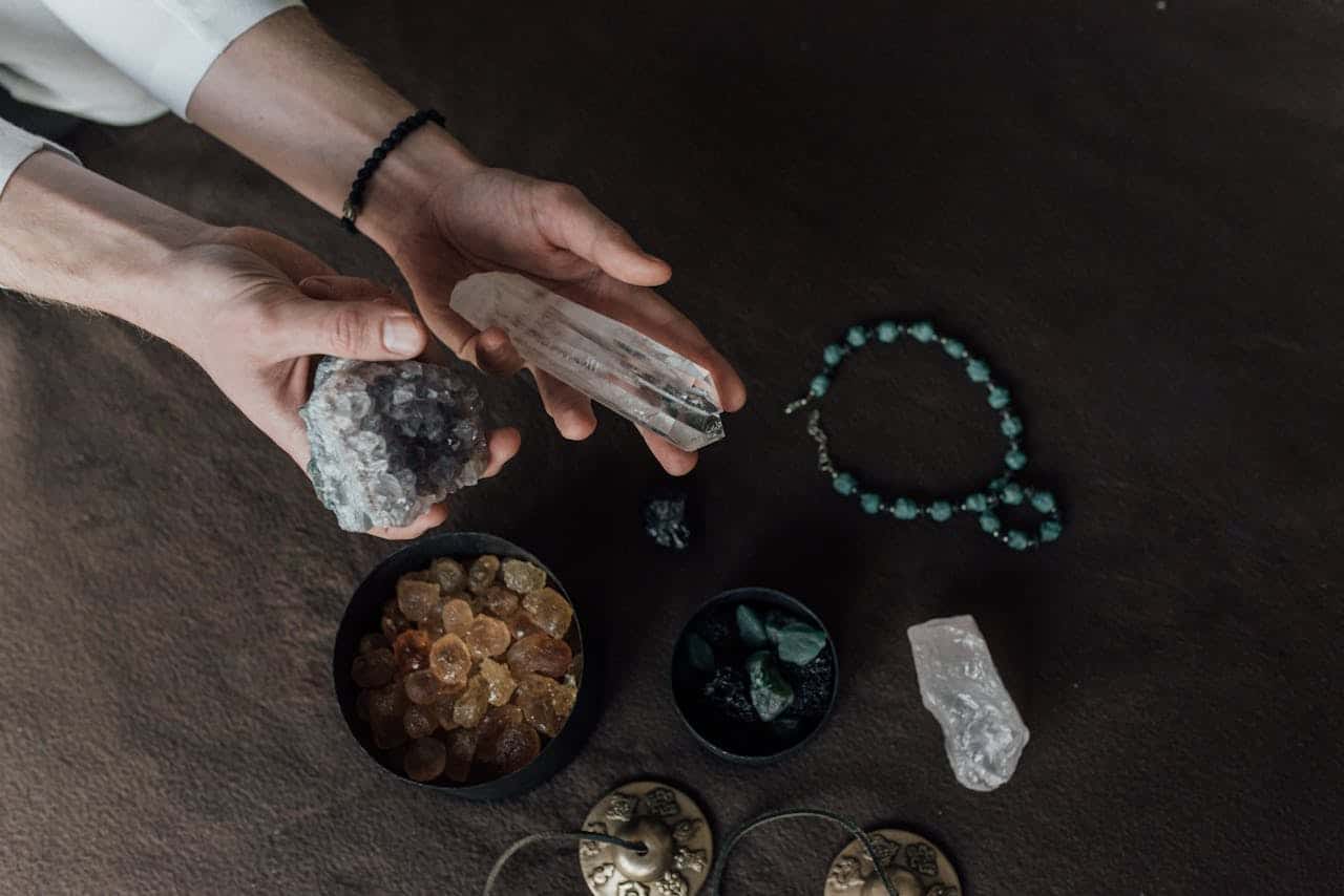 Close-up of hands holding various healing crystals for alternative therapy and meditation.